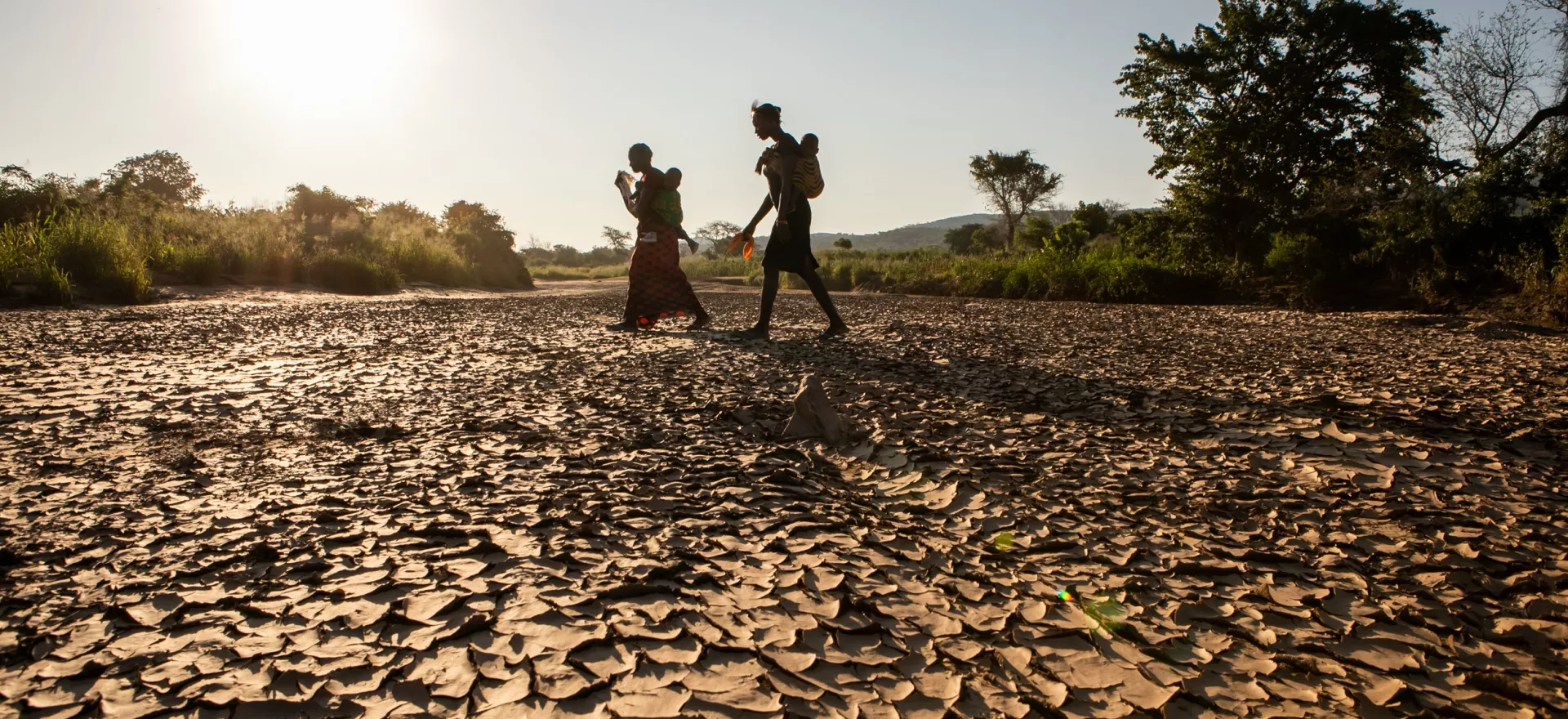 Two woman walk home through a dry riverbed Gwembe Valley, Zambia